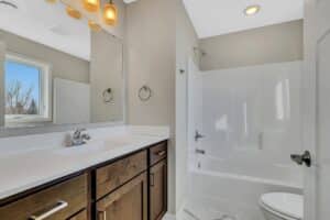Bathroom with white tub and brown vanity