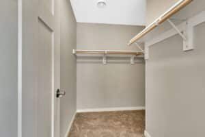 Closet with grey walls and wood hanger bars
