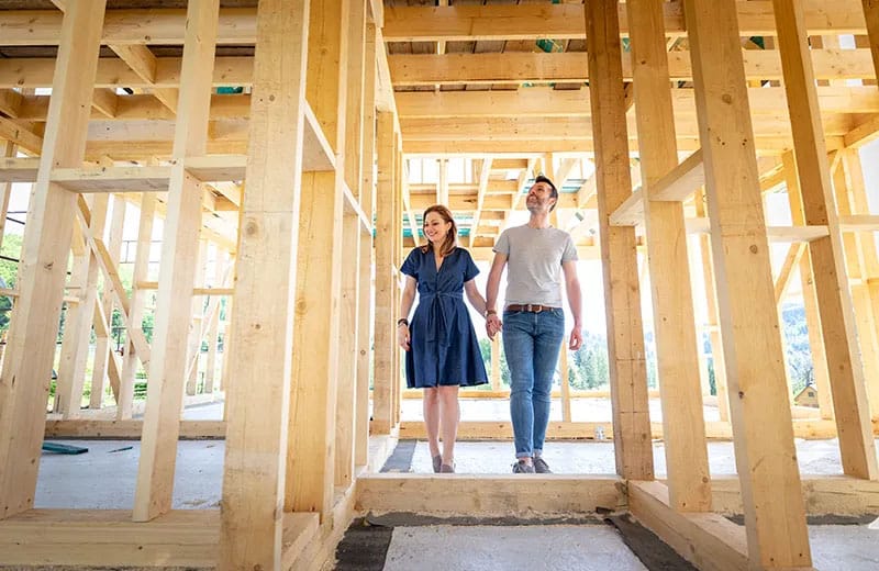 Couple Looking at Framing of House