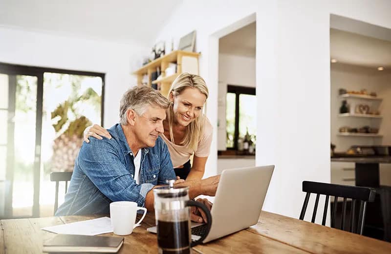 Smiling Couple Reviewing Computer