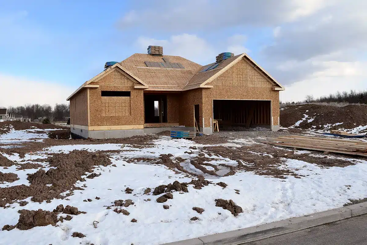 House being built in the winter with snow on ground